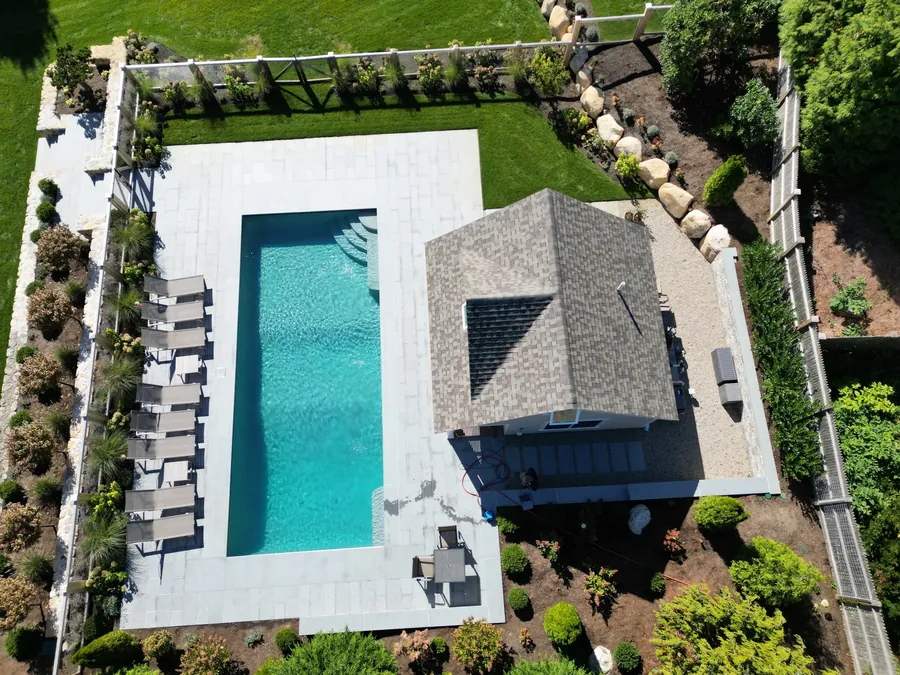 Aerial view of a long rectangular pool beside the house