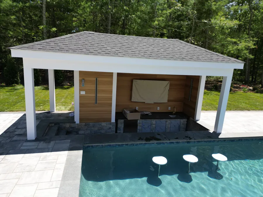 Pool cabana with a TV and swim-up stools in the water