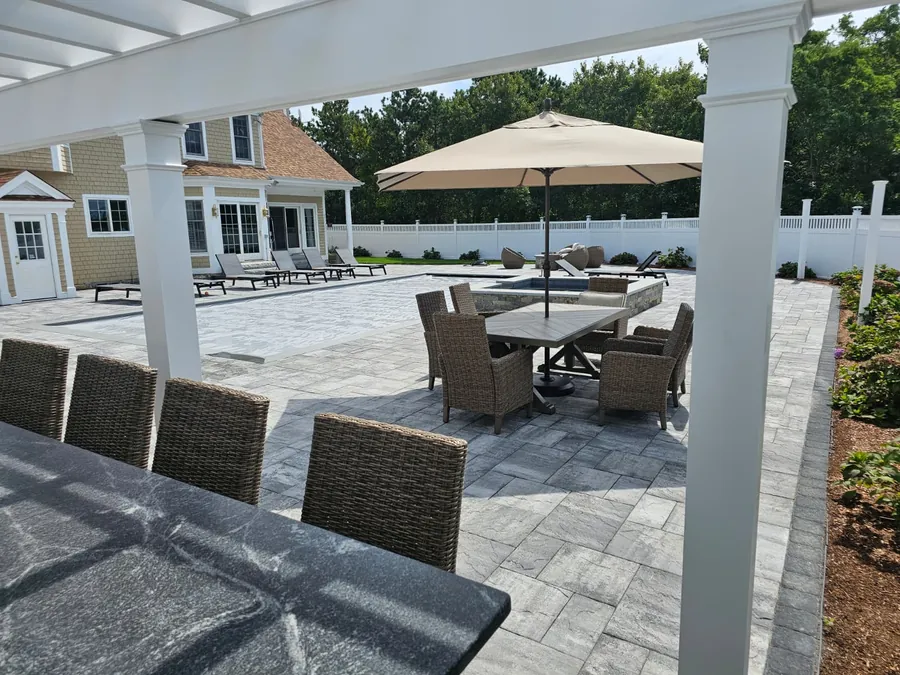 Dining under a pergola next to the pool patio