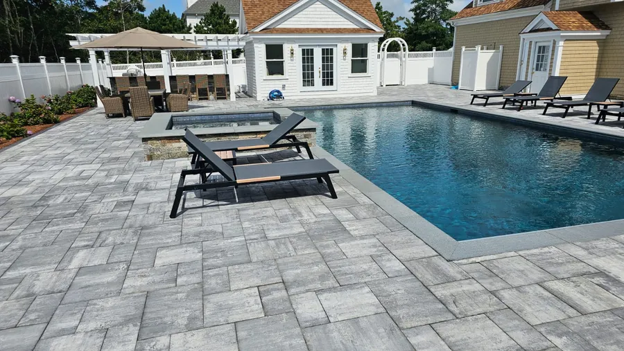 Pool with a paver deck and a pool house