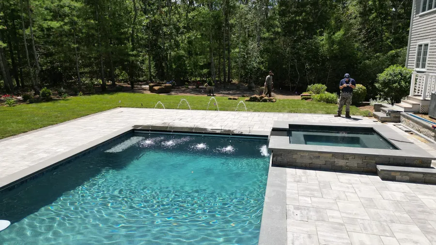 Pool with a raised spa and sheer descents, set in a stone deck