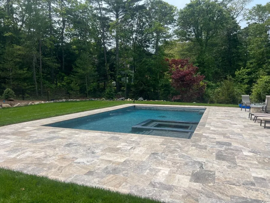 Pool and spa with a natural stone deck and lawn